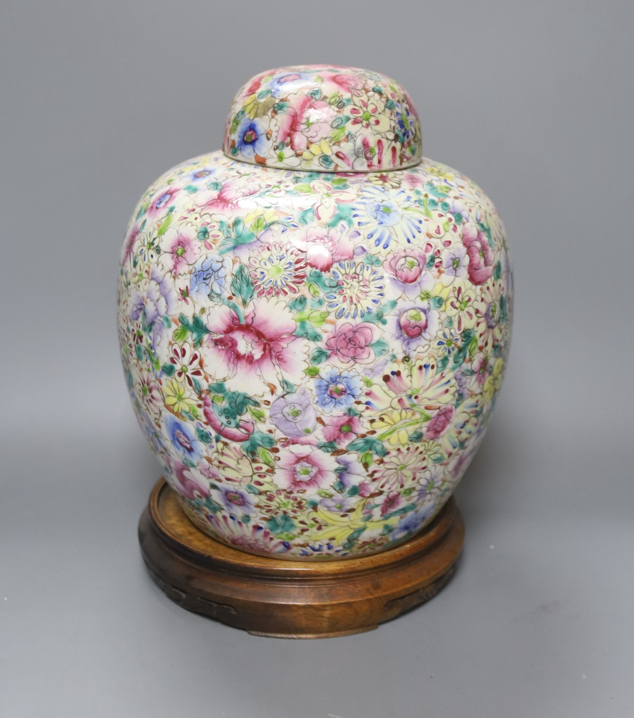 A Chinese thousand flower famille rose jar and cover, early 20th century, wood stand 28cm